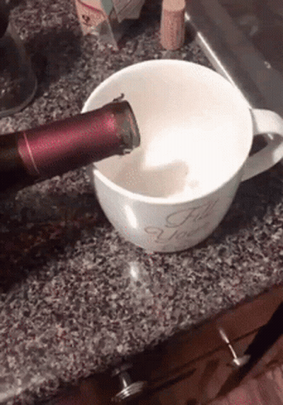 A Bottle Of Wine Is Being Poured Into A Coffee Mug That Says For You GIF