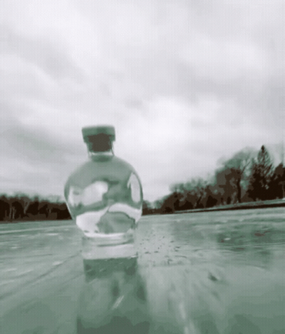 A Bottle With A Cork Is In The Water GIF