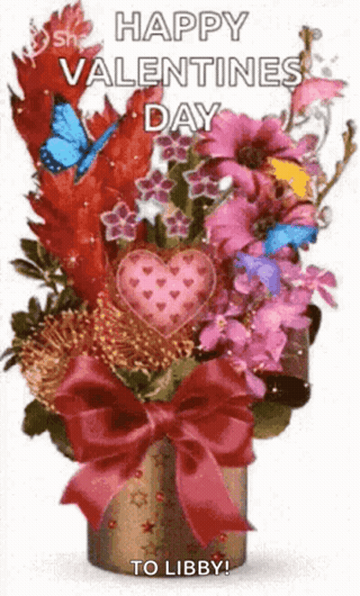 A Bouquet Of Flowers In A Vase With A Bow And A Heart On It . GIF
