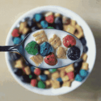 A Bowl Of Cereal With A Spoon Full Of Cereal And Milk GIF