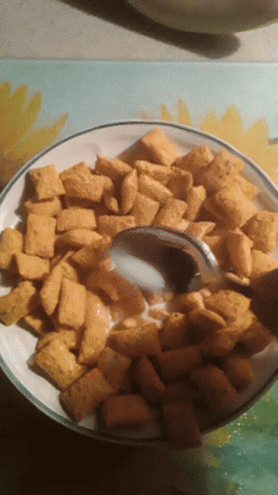 A Bowl Of Cheerios With Milk And A Spoon GIF