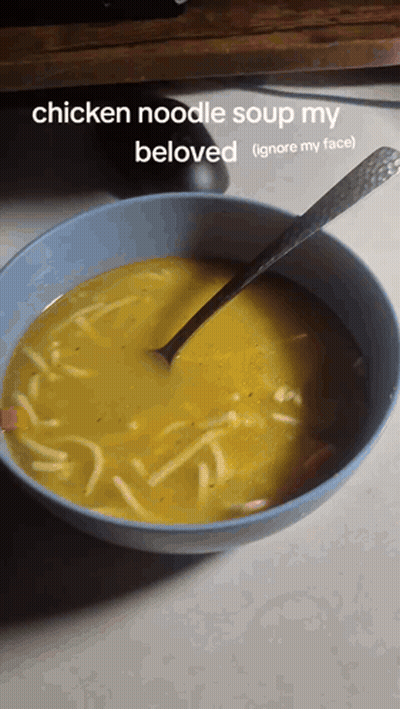 A Bowl Of Chicken Noodle Soup With A Spoon GIF