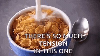 a bowl of cornflakes with milk pouring into it