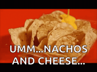 A Bowl Of Nachos With Cheese Being Poured Over Them GIF