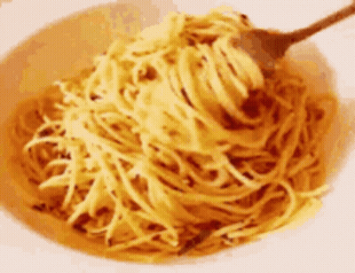 A Bowl Of Noodles With A Spoon In It GIF