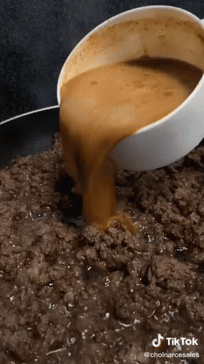 A Bowl Of Sauce Is Being Poured Into A Pan Of Ground Meat GIF