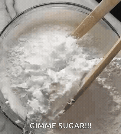 A Bowl Of Sugar With Wooden Spoons In It . GIF