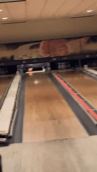 A Bowling Alley With A Painting Of A Cowboy On The Wall GIF