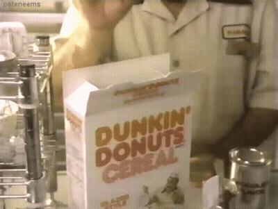 A Box Of Dunkin ' Donuts Cereal Sits In Front Of A Man GIF