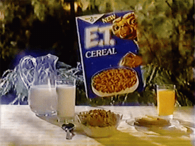 A Box Of Et Cereal Sits On A Table With A Pitcher Of Milk And A Glass Of Orange Juice GIF