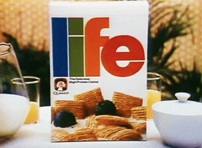 A Box Of Life Cereal Sits On A Table Next To Bowls Of Cereal GIF