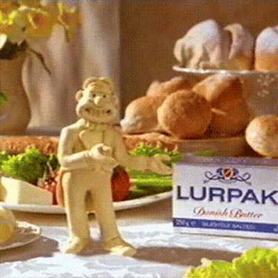A Box Of Lurpak Butter Sits Next To A Figurine Of A Man GIF