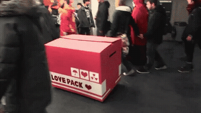A Box That Says Love Pack On It In A Crowded Area GIF