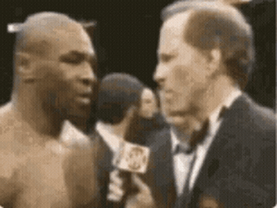 A Boxer Is Being Interviewed By A Man In A Suit And Tie . GIF