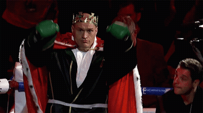 A Boxer Wearing A Crown And Green Boxing Gloves GIF