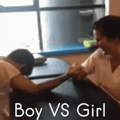 A Boy And A Girl Are Arm Wrestling Each Other . GIF