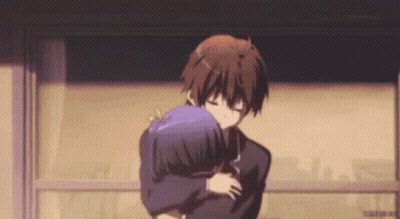 A Boy And A Girl Are Hugging Each Other In A Room . GIF