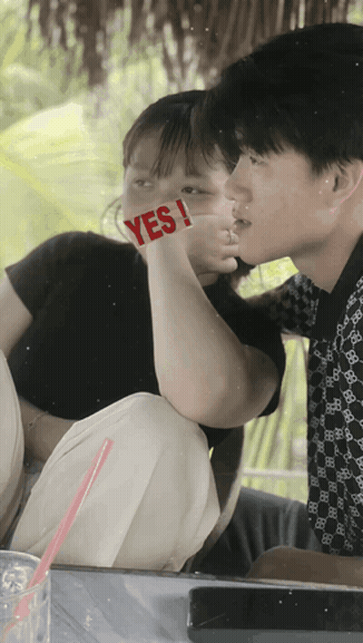 A Boy And A Girl Are Kissing With The Girl Holding A Sign That Says Yes GIF