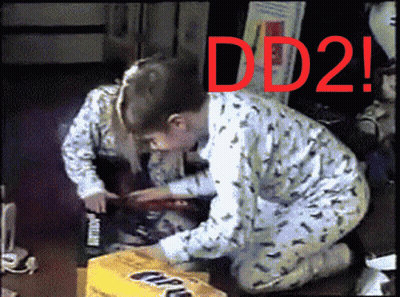 A Boy And A Girl Are Kneeling In Front Of A Box That Says Dd2 GIF