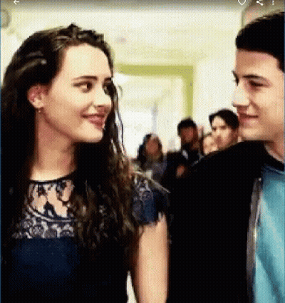 A Boy And A Girl Are Looking At Each Other In A Hallway . GIF