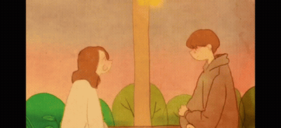 a boy and a girl are looking at each other in a park .