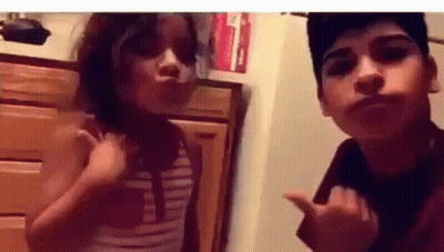 A Boy And A Girl Are Posing For A Picture Together . GIF