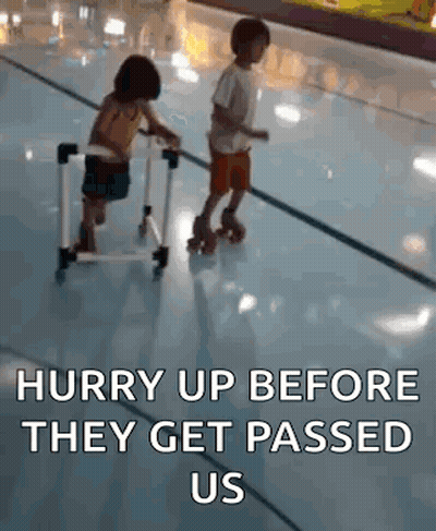 A Boy And A Girl Are Rollerblading On A Rink And The Girl Is Sitting On A Walker . GIF