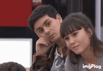 A Boy And A Girl Are Sitting Next To Each Other In A Room . GIF