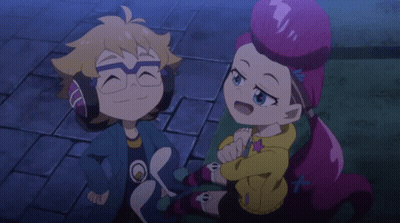 A Boy And A Girl Are Sitting Next To Each Other On A Brick Sidewalk GIF
