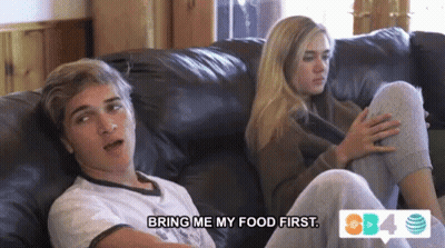 A Boy And A Girl Are Sitting On A Couch And The Girl Is Saying Bring Me My Food First GIF