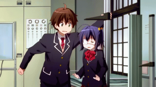 A Boy And A Girl Are Standing In Front Of A Sign That Says Tokyo Mx On It GIF