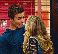 A Boy And A Girl Are Standing Next To Each Other And The Girl Has A Wow Shirt On GIF