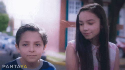 A Boy And A Girl Are Standing Next To Each Other And The Girl Is Smiling GIF