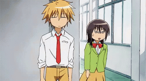 A Boy And A Girl Are Standing Next To Each Other In A Hallway . The Girl Is Wearing A Green Jacket . GIF