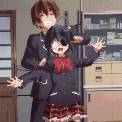 A Boy And A Girl Are Standing Next To Each Other In A Room With A Shelf Full Of Medicine GIF