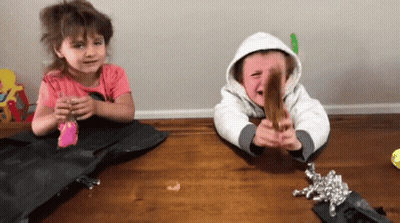 A Boy And A Girl Sitting On A Wooden Table GIF