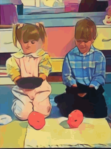 A Boy And A Girl Sitting On The Floor With Apples GIF