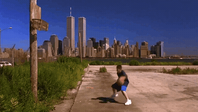 A Boy Dribbles A Basketball In Front Of A City Skyline GIF