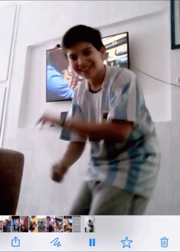 A Boy In A Argentina Shirt Is Dancing In Front Of A Television GIF
