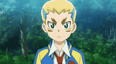 A Boy In A Blue And Yellow Jacket And Tie Is Standing In Front Of Trees . GIF