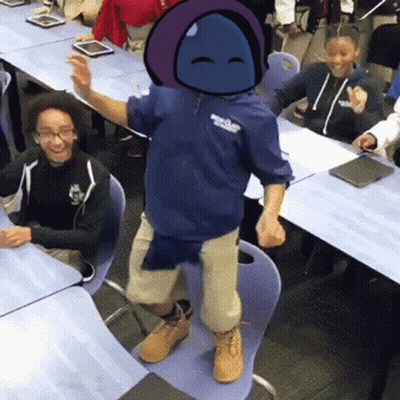 A Boy In A Blue Hoodie Is Standing On A Chair In Front Of A Group Of Children In A Classroom . GIF