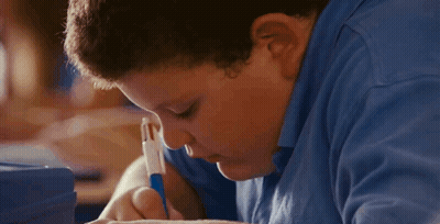 A Boy In A Blue Shirt Is Writing With A Blue Pen GIF
