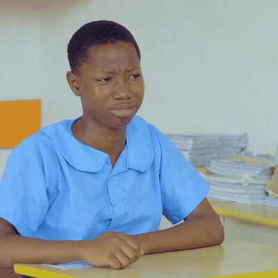 A Boy In A Blue Shirt Sits At A Table GIF