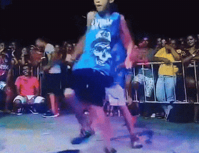 A Boy In A Blue Tank Top With A Skull On It Dancing In Front Of A Crowd GIF
