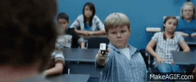 A Boy In A Classroom Is Pointing A Gun At Someone GIF
