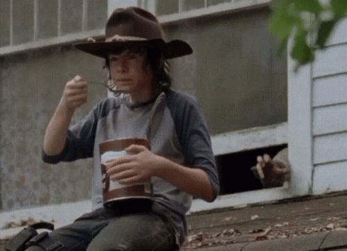 A Boy In A Cowboy Hat Is Eating Ice Cream GIF