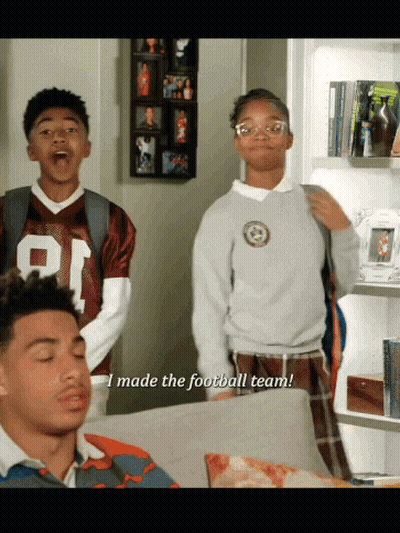 A Boy In A Football Jersey Says " I Made The Football Team " Next To A Girl GIF