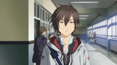 A Boy In A Hoodie Stands In A Hallway Looking At The Camera GIF
