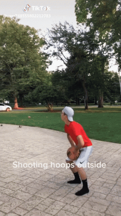 A Boy In A Red Shirt Is Playing Basketball Outside GIF