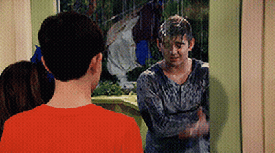 A Boy In A Red Shirt Is Standing In Front Of A Window With A Man In A Gray Shirt Covered In Slime . GIF